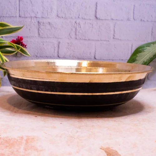 Brass and black striped basin paraat on a light surface with a gray brick wall background-Zishta Traditional Kitchen Accessories