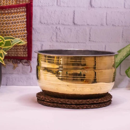 Brass Cooking Pot Vaana placed on woven base on a white surface-Zishta Traditional Cookware