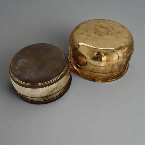 Two brass Vaana Cooking pots with different finishes, one with a natural finish and another with a polished finish, on a gray background-Zishta Traditional Cookware