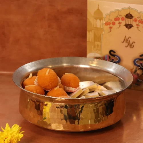 Brass Lagan with sweets on a wooden surface with a decorative card in the background-Zishta Traditional Cookware