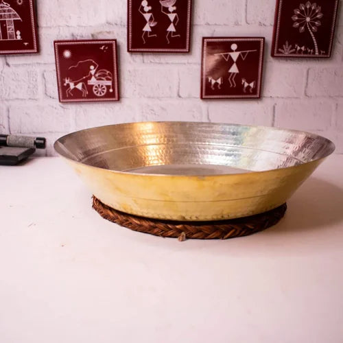 Brass Paraat with Tin Coating on a white surface with decorative wall art in the background-Zishta Traditional Kitchen Accessories