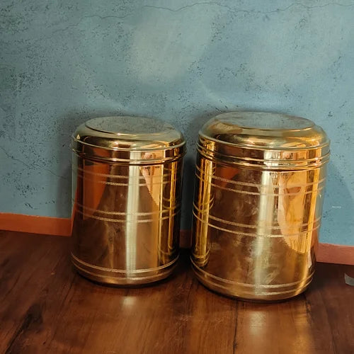 Two brass storage containers on a wooden surface with a blue wall background-Zishta Traditional Storage Containers