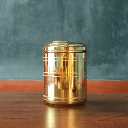 Brass Storage container on a wooden surface with a blue textured wall background-Zishta Kitchen Storage Containers