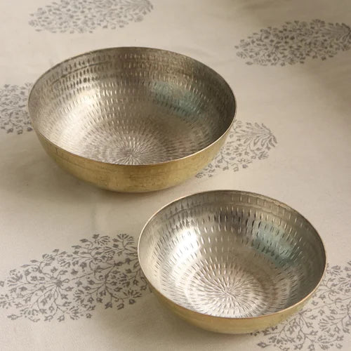 Two Brass Tasla Kadais with textured surface on a patterned fabric background-Zishta Traditional Cookware