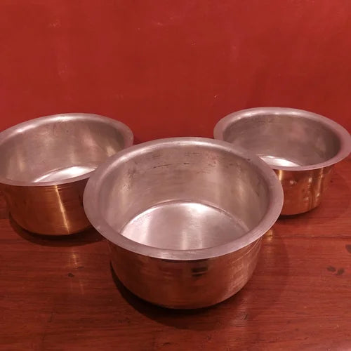 Three Brass Tope Bhagonas on a wooden surface with a red background-Zishta Traditional Cookware