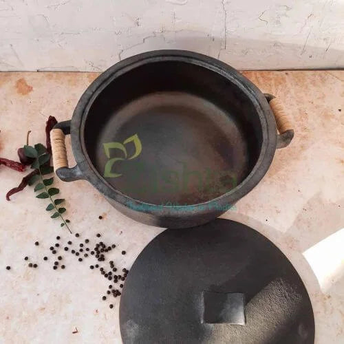 Manipur Black Pottery Casserole with wooden handles on a light surface with spices and herbs-Zishta Traditional Cookware