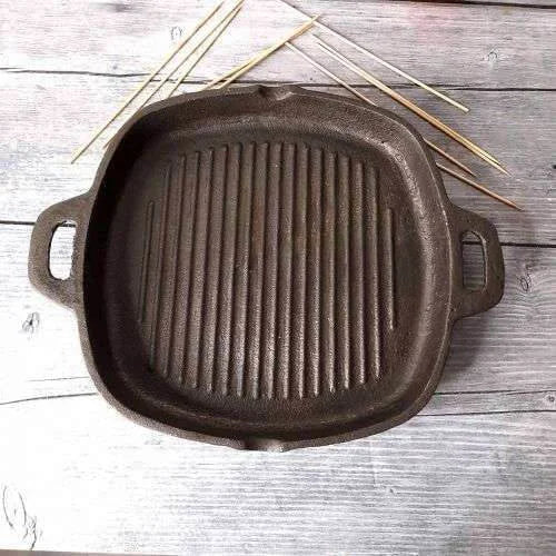 Cast iron grill pan on a wooden surface with skewers-Zishta Traditional Cookware