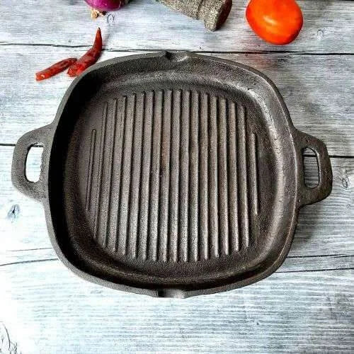 Cast iron grill pan on a wooden surface with vegetables-Zishta Traditional Cookware