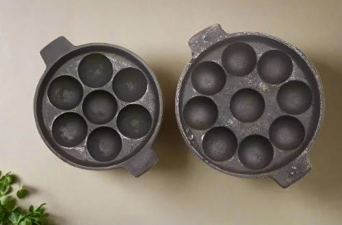 Two Cast Iron Kuzhipaniyaram Pan-Appe Tawas, 7 and 9 cavities, on a beige background-Zishta Traditional Cookware