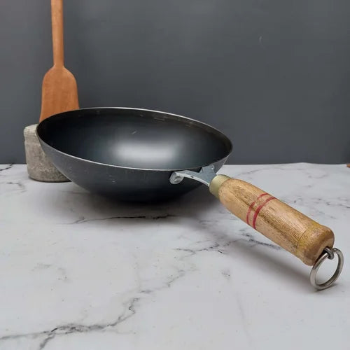 Handcrafted Pure Iron wok with wooden handle on a marble surface-Zishta Traditional Cookware
