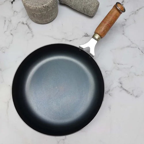 Handmade Iron frying pan with a wooden handle on a marble surface-Zishta Traditional Cookware