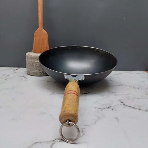 Iron wok with wooden handle on a marble surface-ZIshta Traditional Cookware
