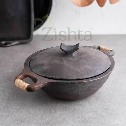 Manipur Longpi Black Pottery Kadai with wooden handles on a gray surface-Zishta Traditional Cookware