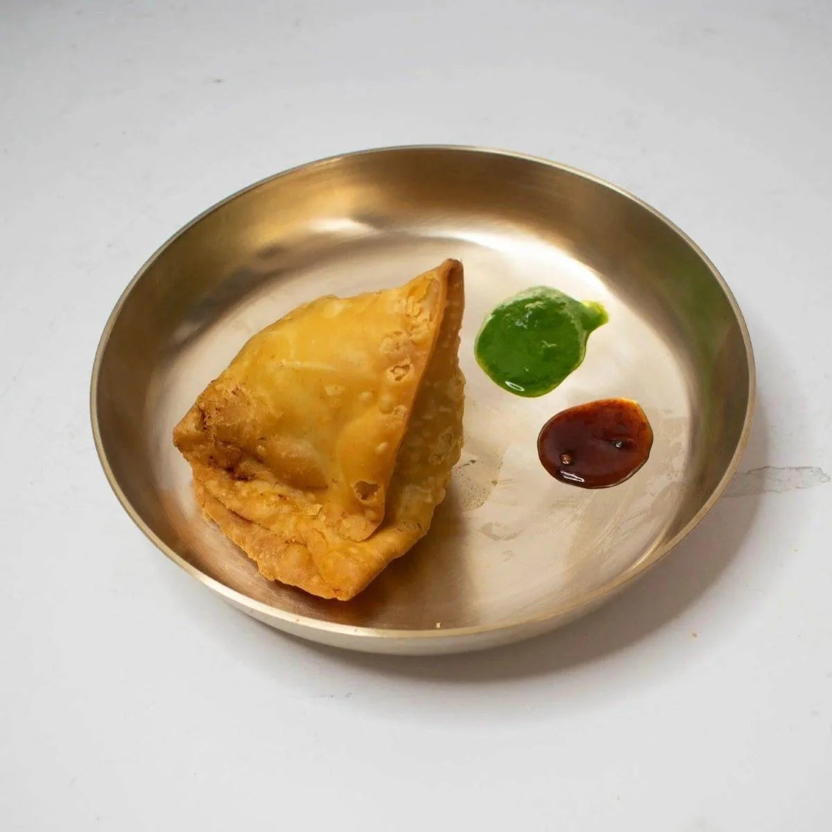 Samosa served with green and sweet chutney in a Kansa Snack Plate-Zishta Traditional Serveware