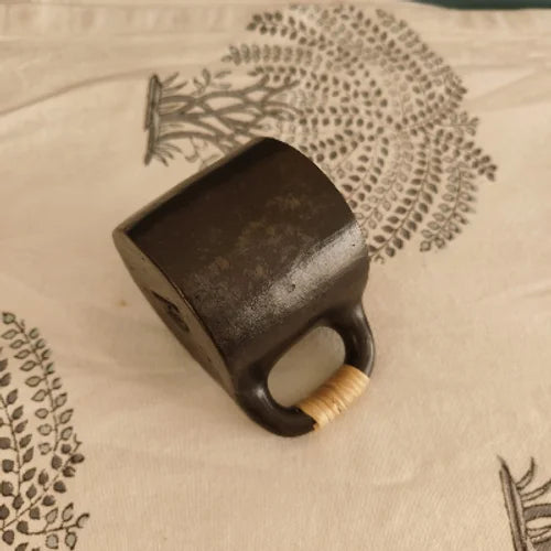 Manipur Black Pottery Tea Coffee Cup with a wooden handle on a textured surface-Zishta Traditional Serveware