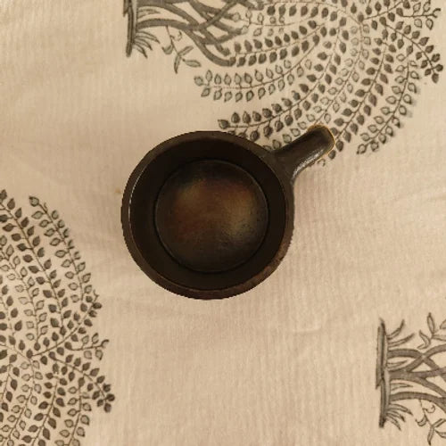 Manipur Black Pottery Tea Coffee Cup on a beige surface with leaf patterns-Zishta Traditional Serveware