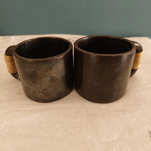 Two Manipur Black Pottery Tea Coffee Cups with wooden handles on a beige surface-Zishta Traditional Serveware