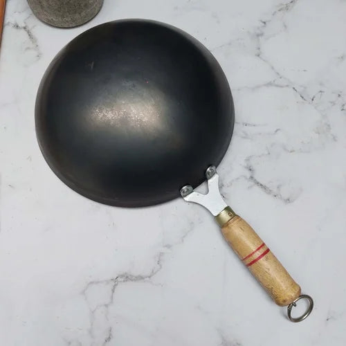 Iron Wok with a wooden handle on a marble surface-Zishta Traditional Cookware