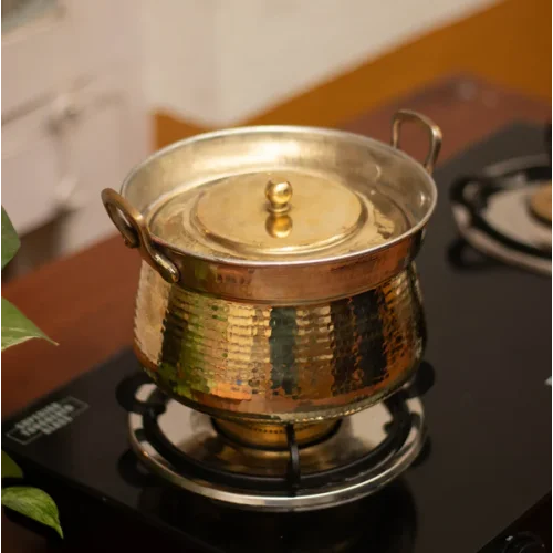 Shakuntala Patra Brass Cooking pot with lid on a stove-Zishta Traditional Cookware