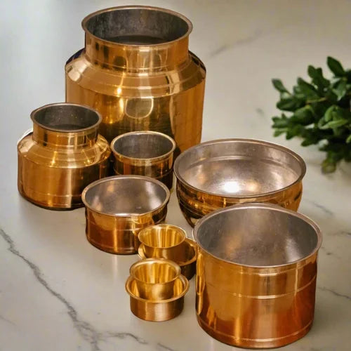 Brass Rail Adukku Set on a marble surface with a plant in the background-Zishta Traditional Brass Cookware