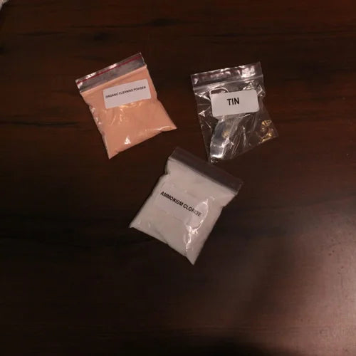 Zishta Kalai Kit Accessories-Three small plastic bags with labeled contents on a dark surface