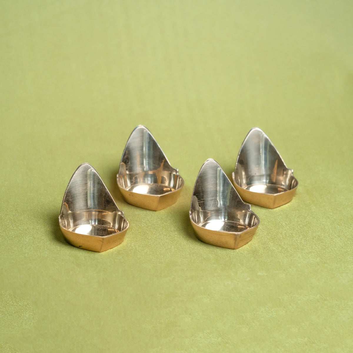 Four Brass Mada Vilakku Deepams on a green background-Zishta Traditional Decor-Navratri Gifting