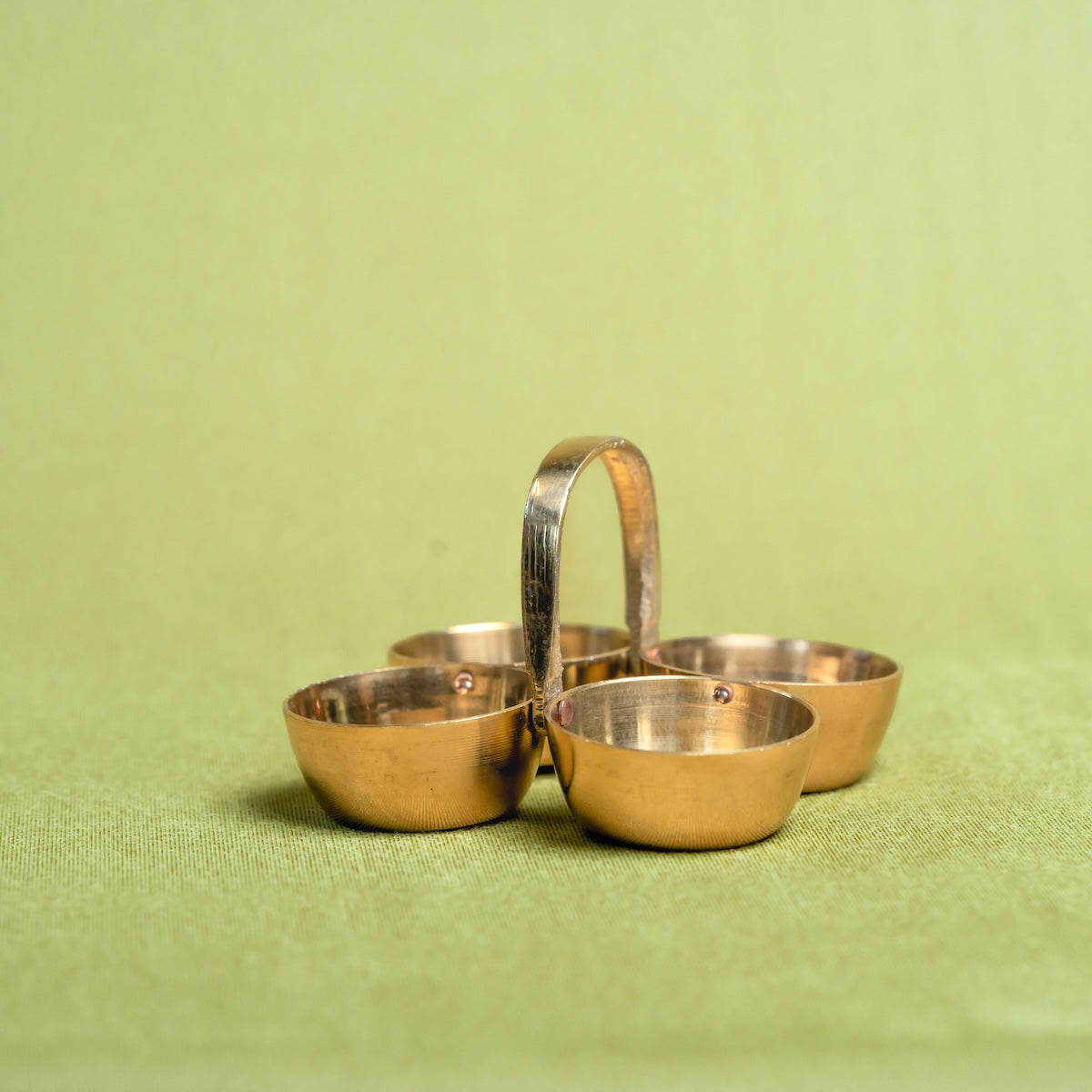 Brass Pooja Chowmukh-Four compartment basket on a green fabric background-Zishta Traditional Decor-Navratri Gifting