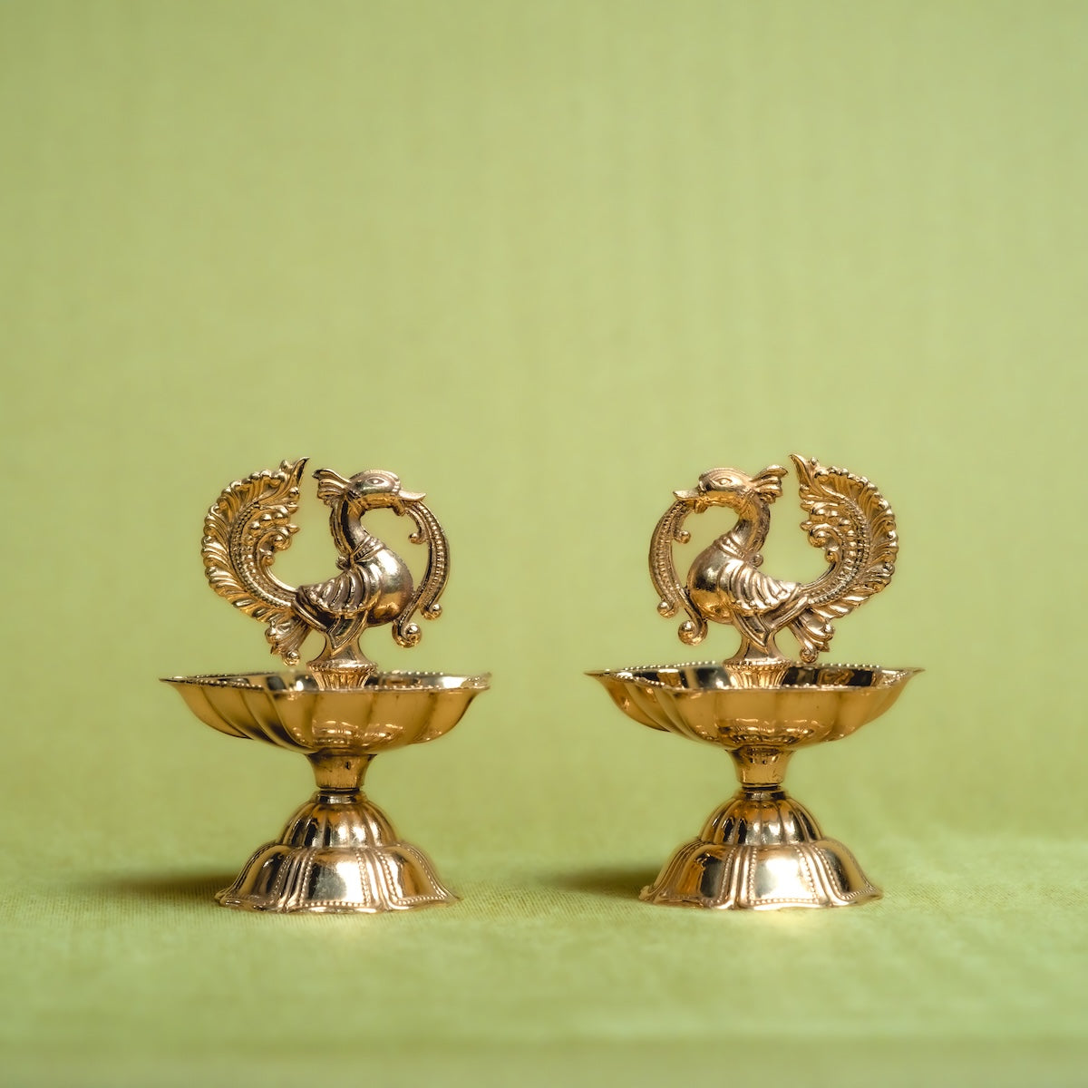 Two Brass Annam Diya Set-decorative items with intricate designs on a green background-Zishta Traditional Decor-Diwali and Navratri Gifts