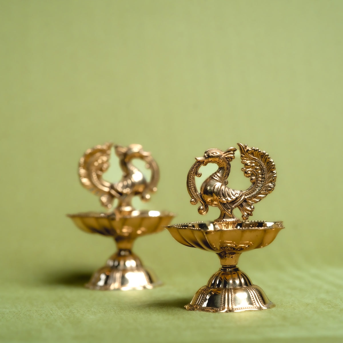 Two Brass Annam Diyas-decorative items with intricate designs on a green background-Zishta Traditional Decor-Diwali and Navratri Gifts