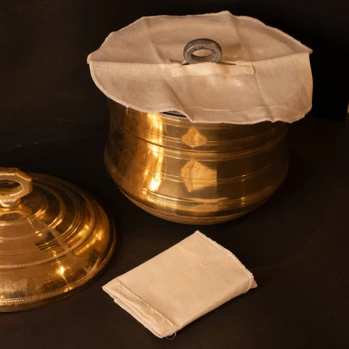 Traditional Brass Idli Pathram-Vessel with a white cloth cover for idli plates on a dark background-Zishta Traditional Cookware
