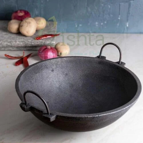 Black cast iron kadai on a kitchen counter with vegetables in the background-Zishta Traditional Cookware