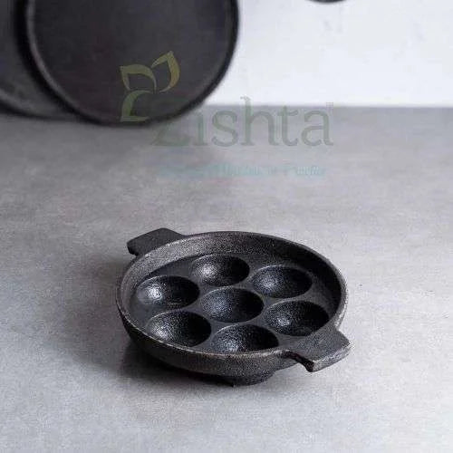 Cast iron Kuzhi paniyaram Kal-Paddu pan with 7 cavities on a gray surface-Zishta Traditional Cookware