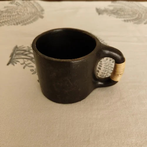 Manipur Black Pottery Tea Coffee Cup with a wooden handle on a textured surface-Zishta Traditional Serveware