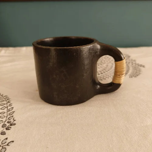 Manipur Black Pottery Tea Coffee Cup with a wooden handle on a textured surface-Zishta Traditional Serveware