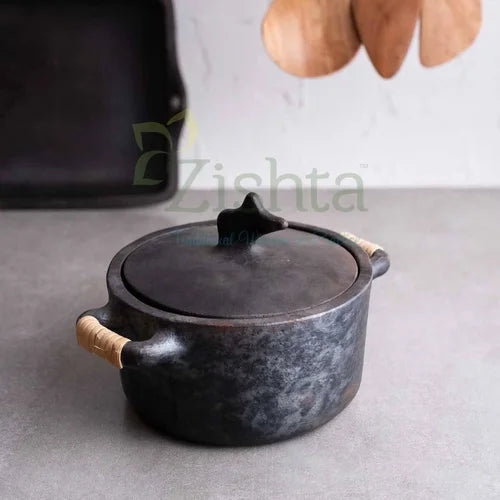 Mesthin Manipur Black Pottery-Longpi Pottery with wooden handles on a gray surface-Zishta Traditional Cookware