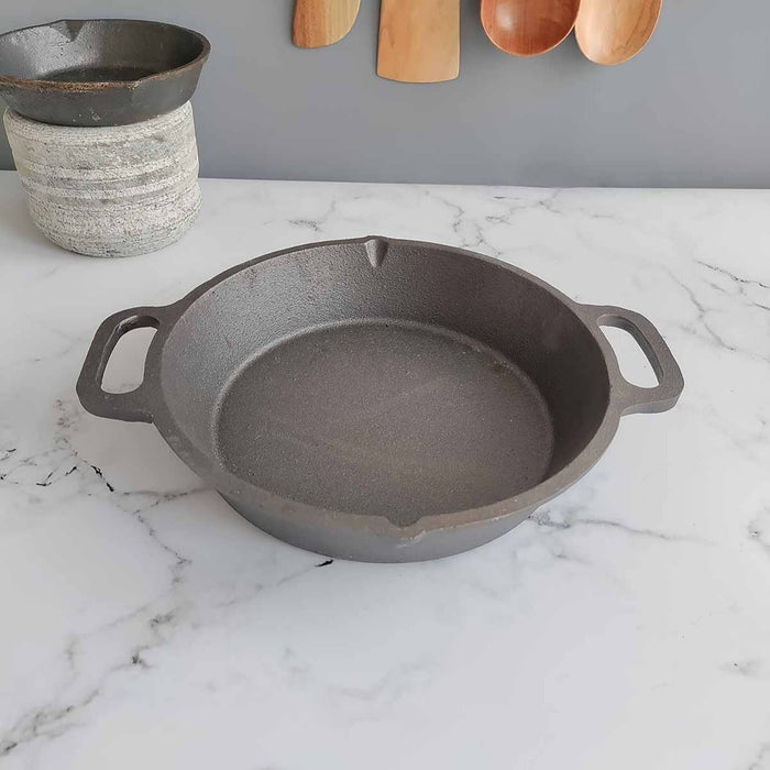 https://zishta.com/cdn/shop/products/cast-iron-loop-round-skillet-pan-dual-handle-zishta-traditional-cookware_700x700.jpg?v=1655741321