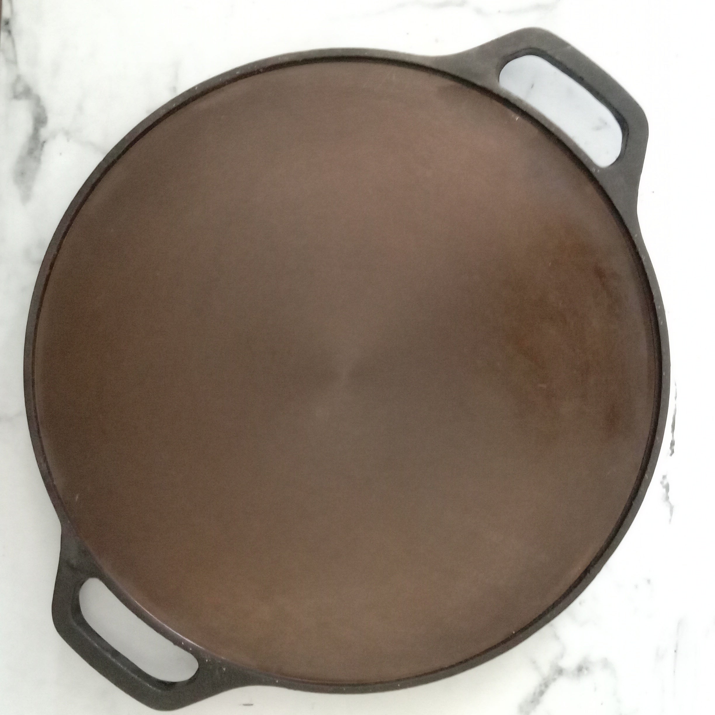 https://zishta.com/cdn/shop/products/cast-iron-tawa-smooth-finish-double-handle-1-zishta-traditional-cookware.jpg?v=1679646850&width=2448